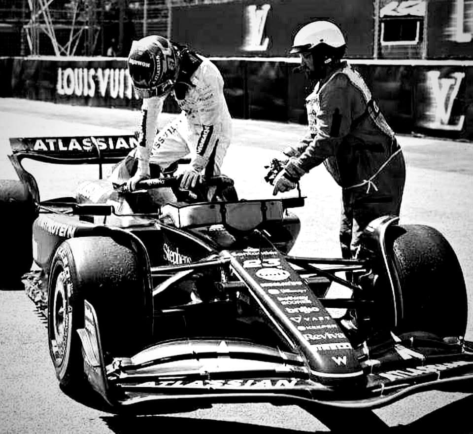 Sam aidant un pilote de Formule 1 à sortir de sa monoplace sur le circuit
